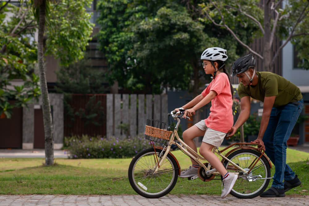 Gambar ini merefleksikan pembahasan dalam artikel, yaitu cara belajar hal baru pada seorang anak kecil yang sedang menaiki sepeda